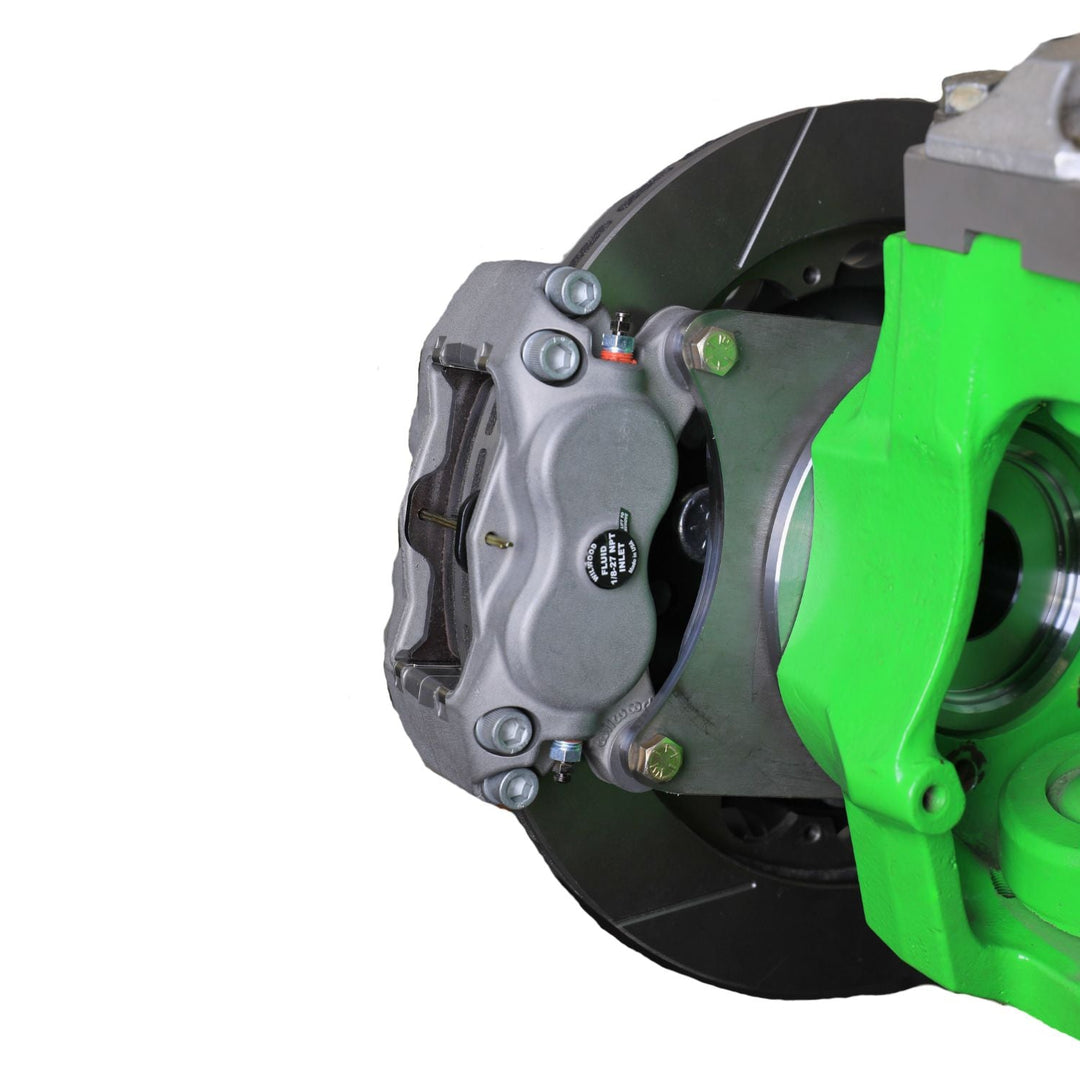 Close-up of a Dana 60 Ultra4 brake conversion with a green caliper on a white background