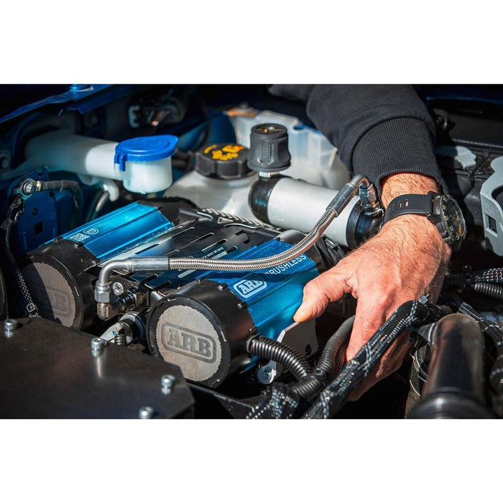 Hand adjusting a blue and black arb smart start onboard twin air system on a car engine with &