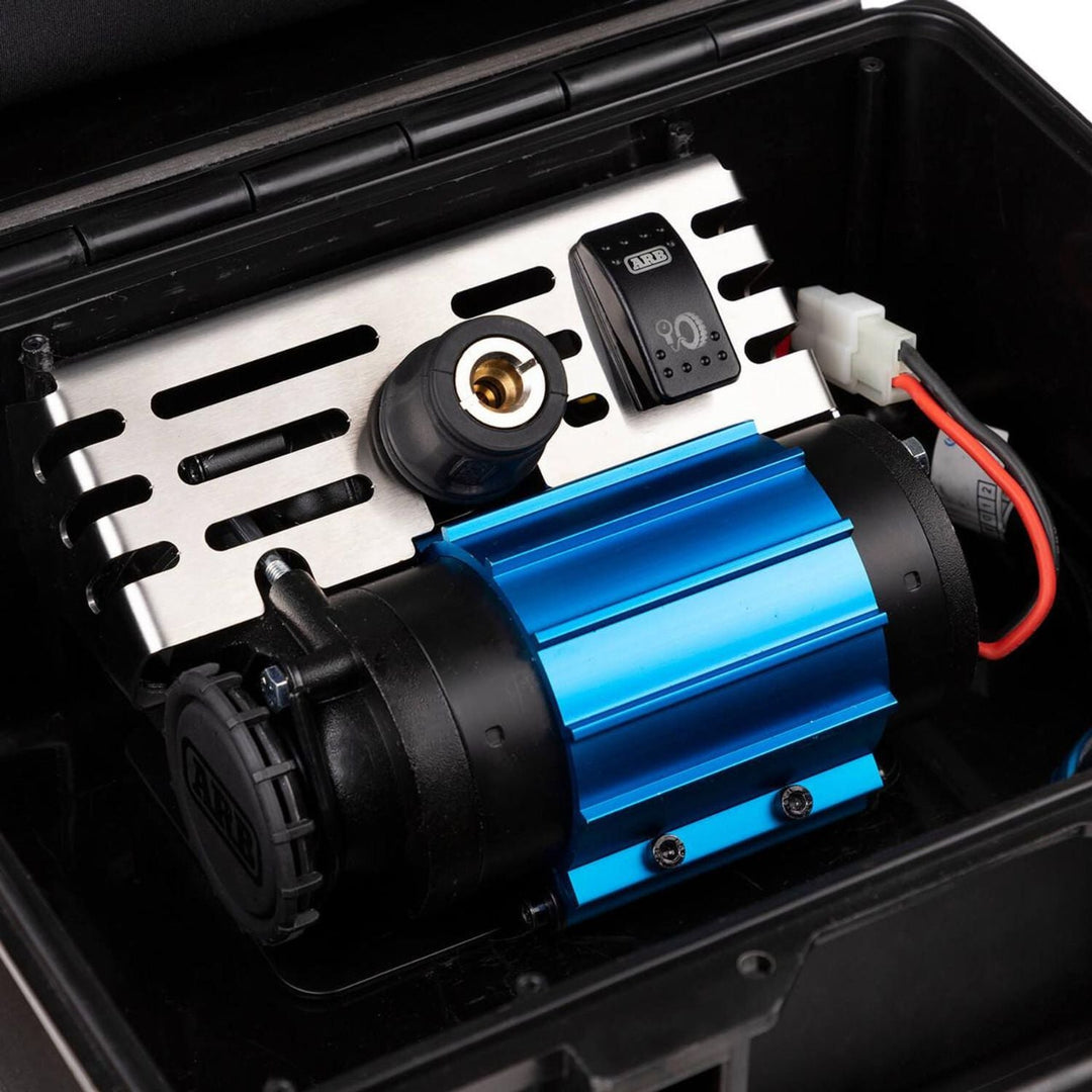 Blue and black compact 12v compressor for tire inflation inside a black toolbox