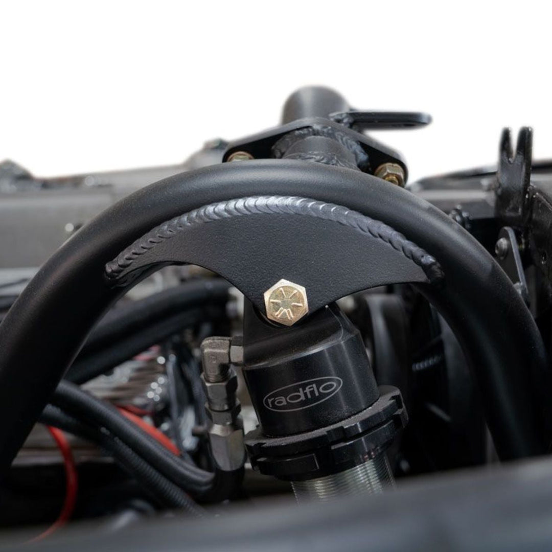 Close-up of weld on 1/4" laser cut off road shock brackets with 'radflo' branding on a blurred background